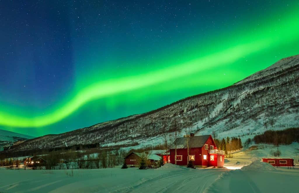 Groen noorderlicht en uitzicht op de bergen in Noorwegen